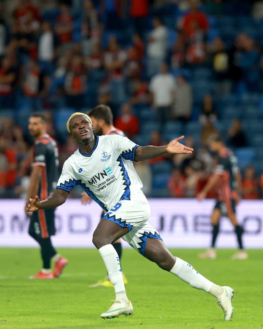 Yves Erick Bile (Hapoel Petah Tikva) celebrates with arms outstretched