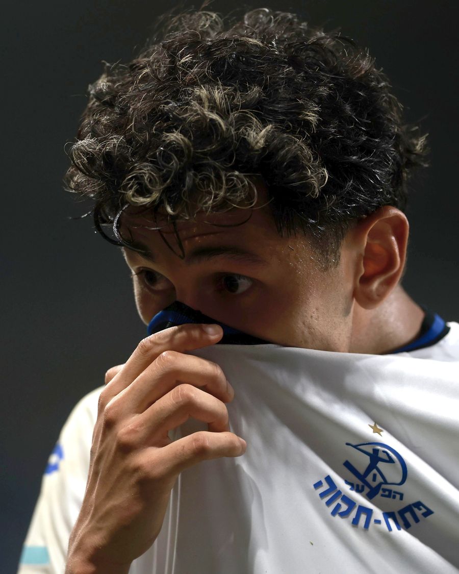 A Hapoel Petah Tikva player is covering his mouth with his shirt