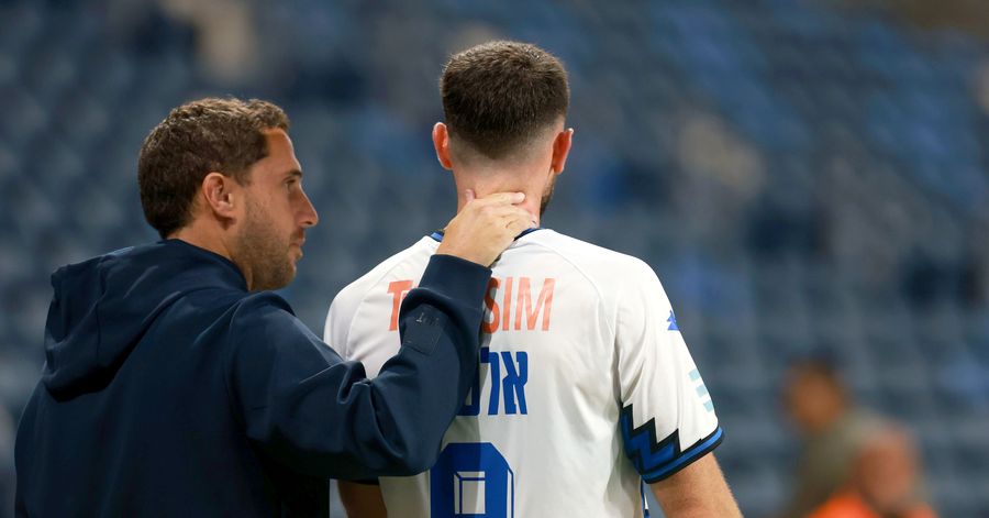 A Hapoel Petah Tikva player is standing with hand on neck
