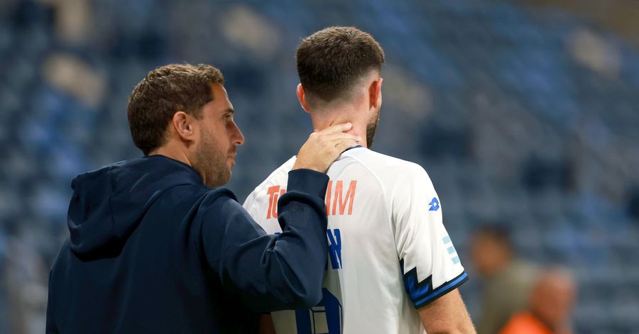 A Hapoel Petah Tikva player receives a pat on the back from the coach