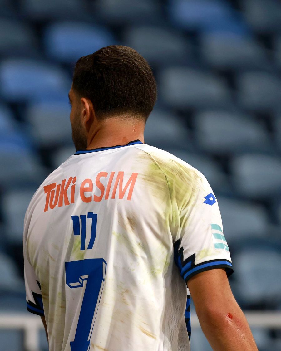 A Hapoel Petah Tikva player walks towards the right side of the field