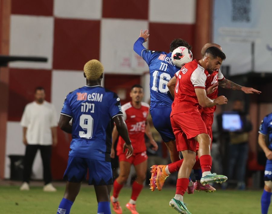 A Bnei Sakhnin player heads the ball while jumping