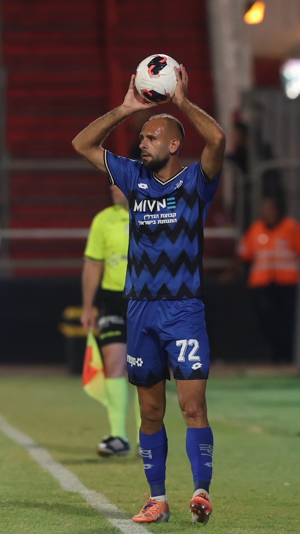 Yazen Nassar (#72, Hapoel Petah Tikva) is holding the ball above his head