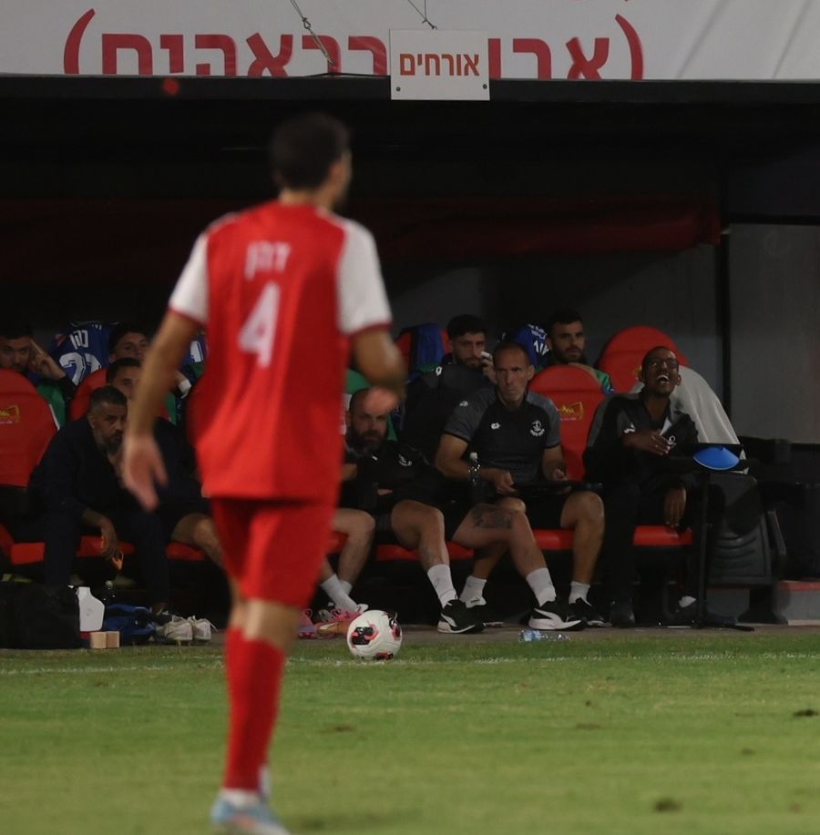 A Bnei Sakhnin player Player in red and white kit walking towards the ball.