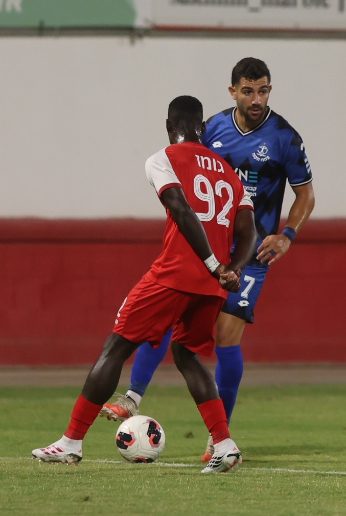 Saná (#92, Bnei Sakhnin) controls the ball with his right foot as Roy Levy (#7, Hapoel Petah Tikva) is attempting to block the ball