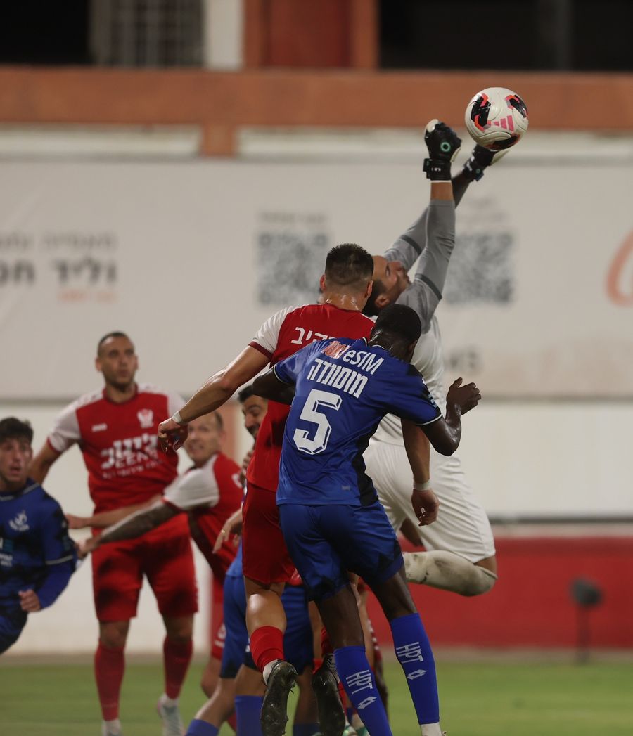 A footballer competes for an aerial ball