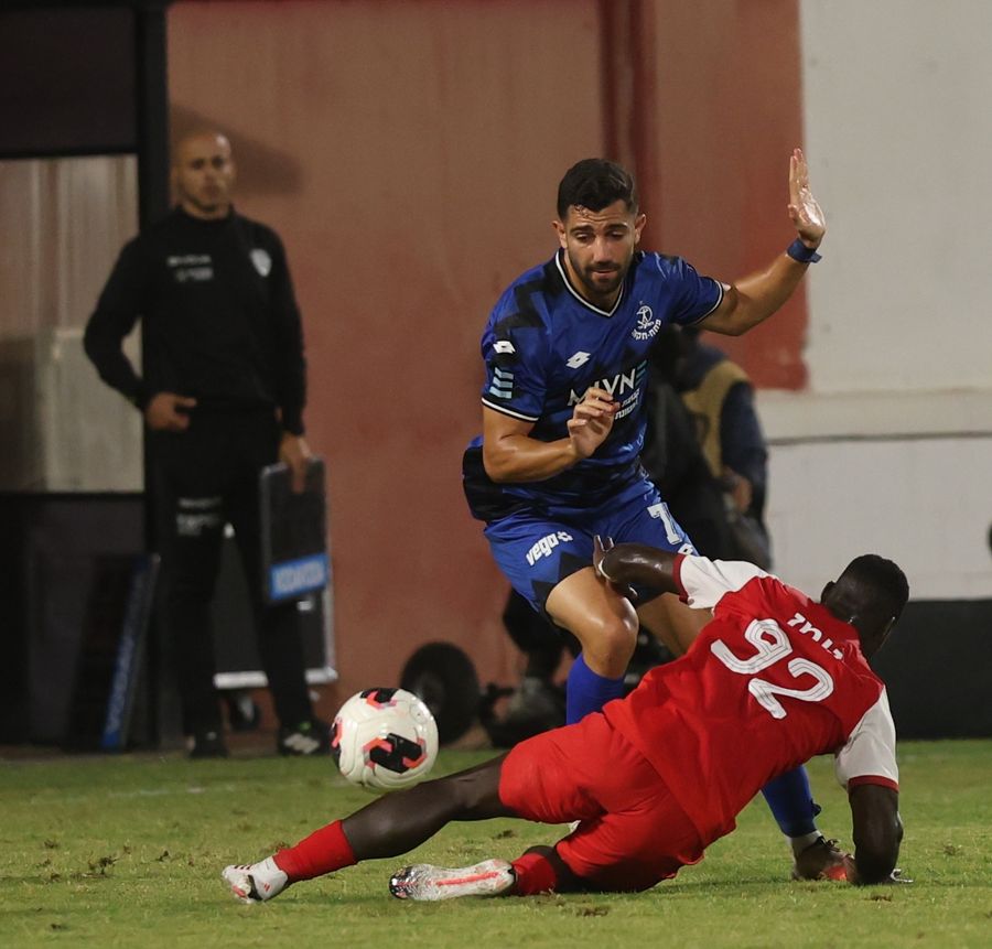 A footballer is attempting to control the ball