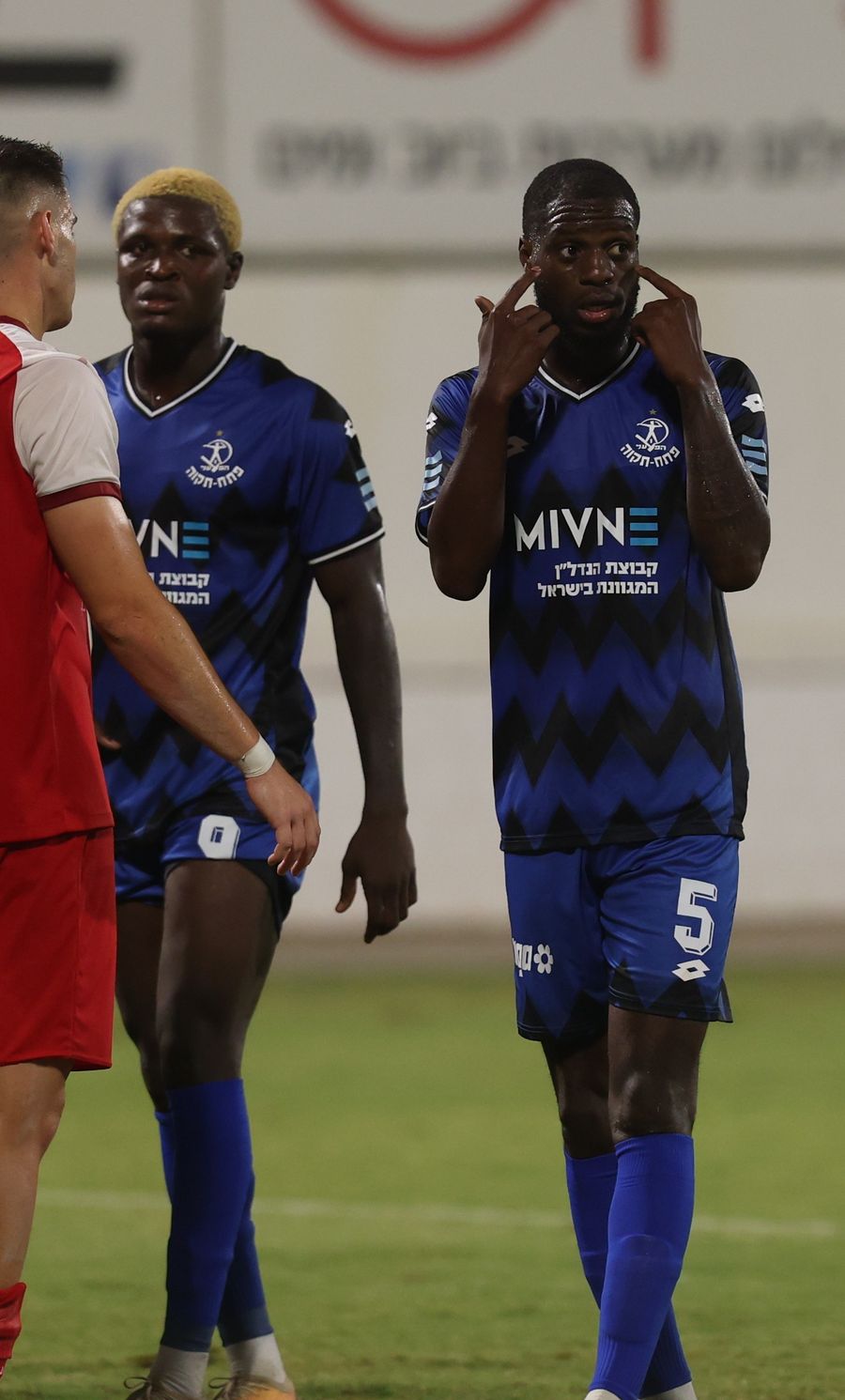 Alex Moussounda (Hapoel Petah Tikva) and Yves Erick Bile (Hapoel Petah Tikva) walk towards the camera with a concerned expression