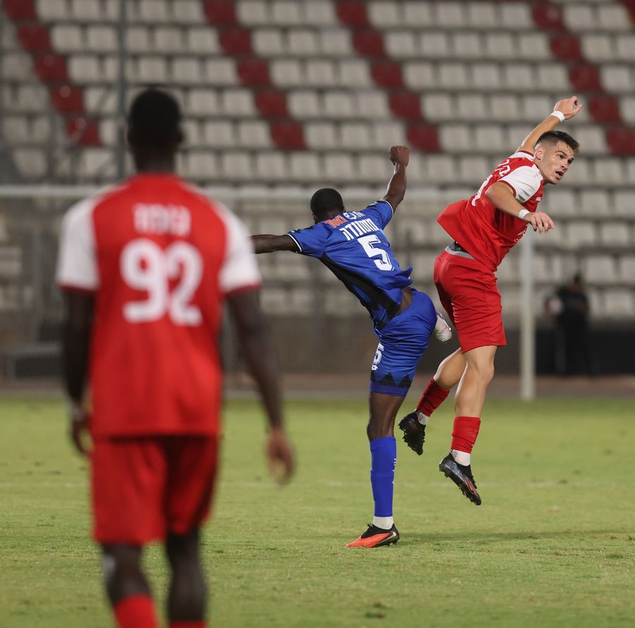 Daniel Paraschiv (Bnei Sakhnin) jumps with arms raised, possibly celebrating or reacting to a play