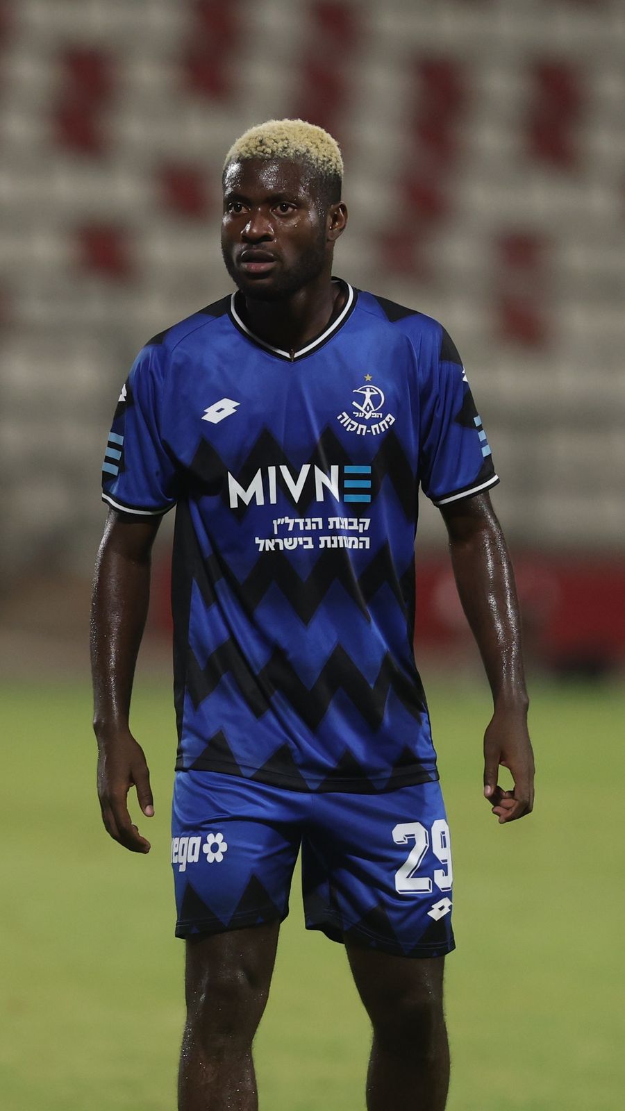 Boni Amian (#29, Hapoel Petah Tikva) is standing on the field, looking ahead