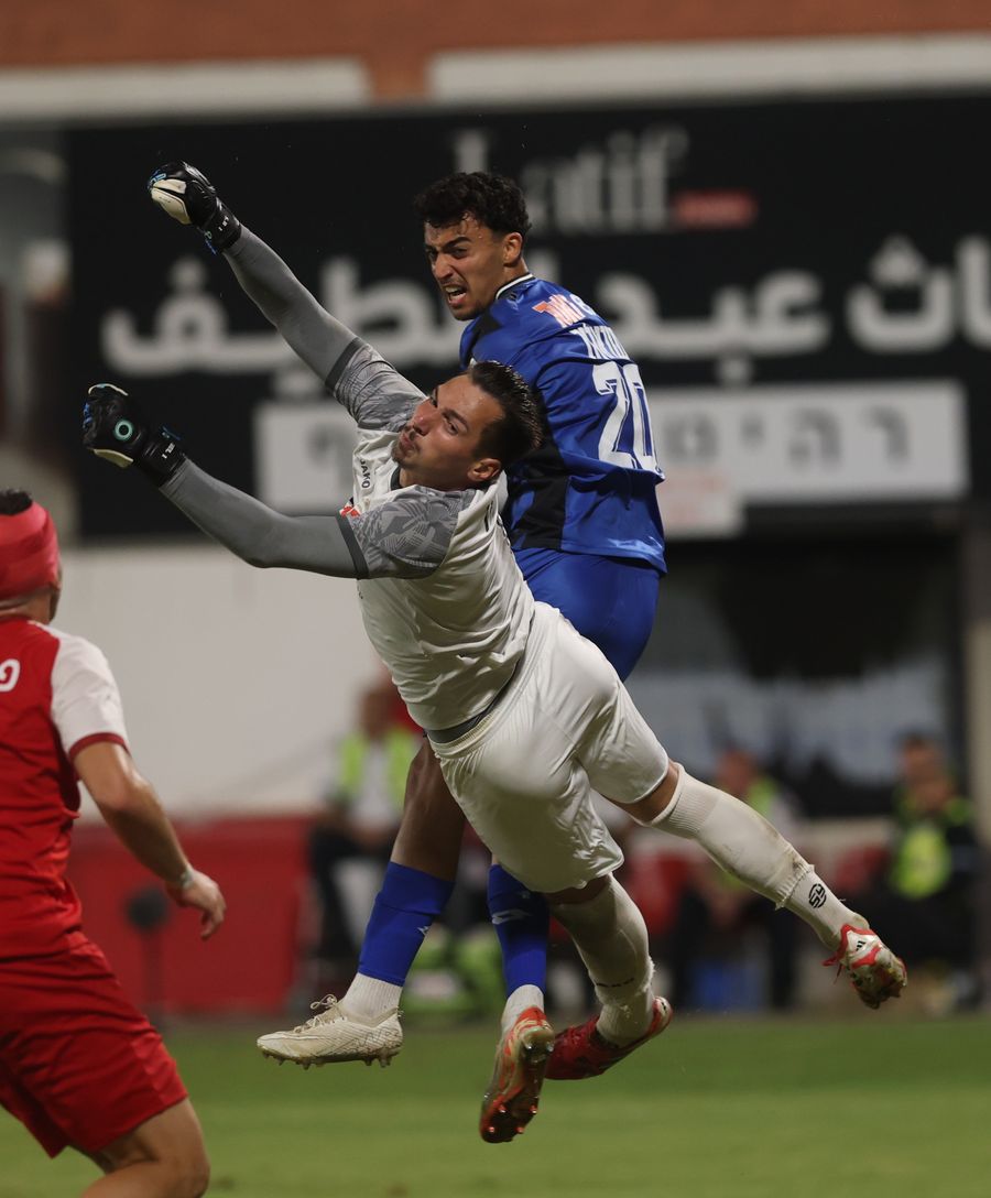 Raul Balbarau (Bnei Sakhnin) is attempting to block a header