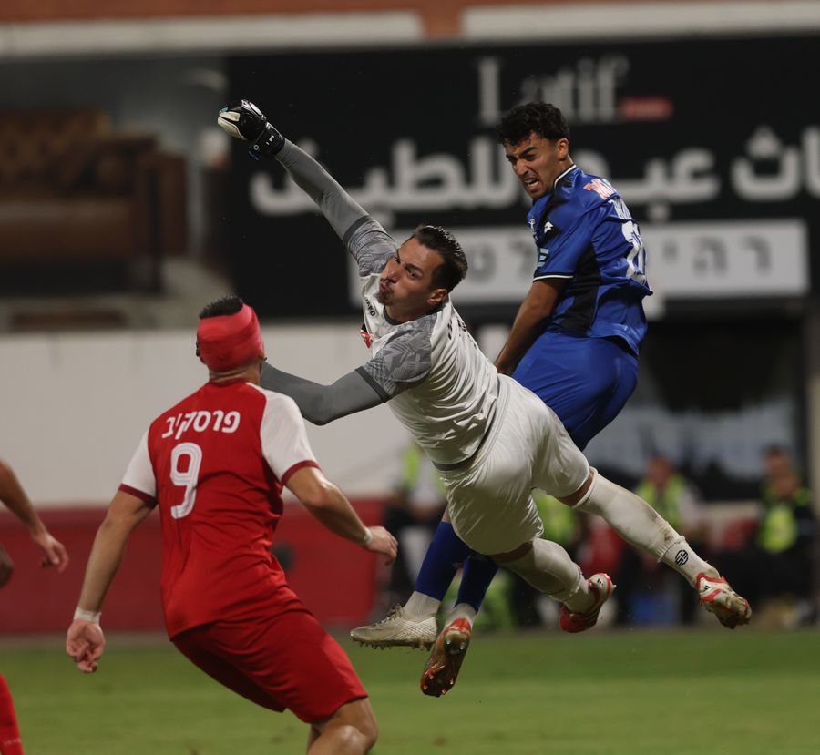 Raul Balbarau (Bnei Sakhnin) jumps to head the ball