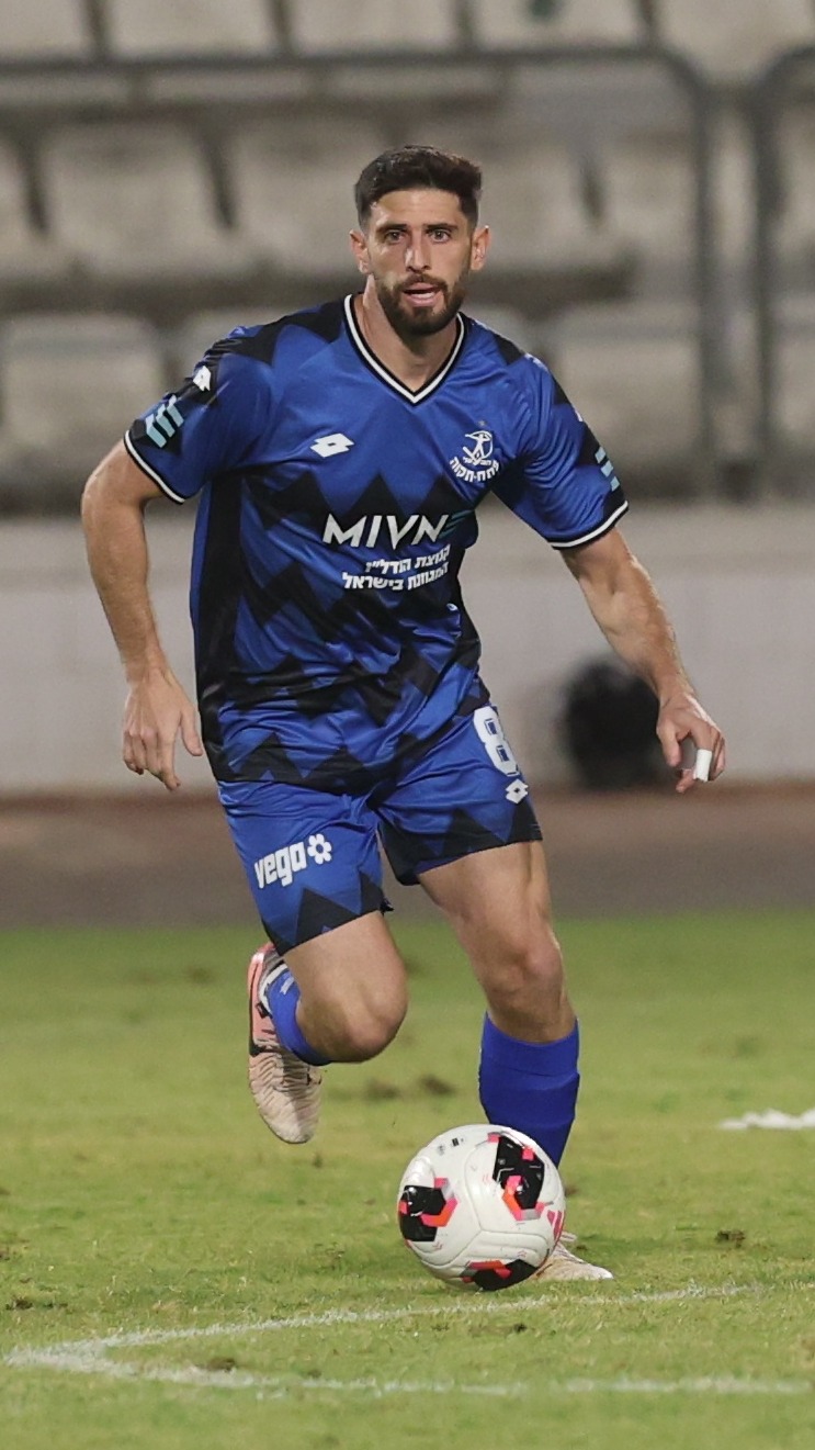 Tomer Altman (#8, Hapoel Petah Tikva) Player in blue uniform dribbling the ball down the field.