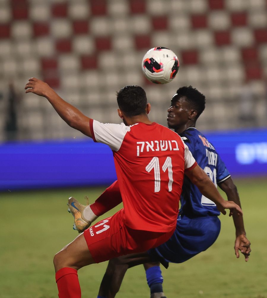 Jabeir Bushnak (#11, Bnei Sakhnin) competes for an aerial ball