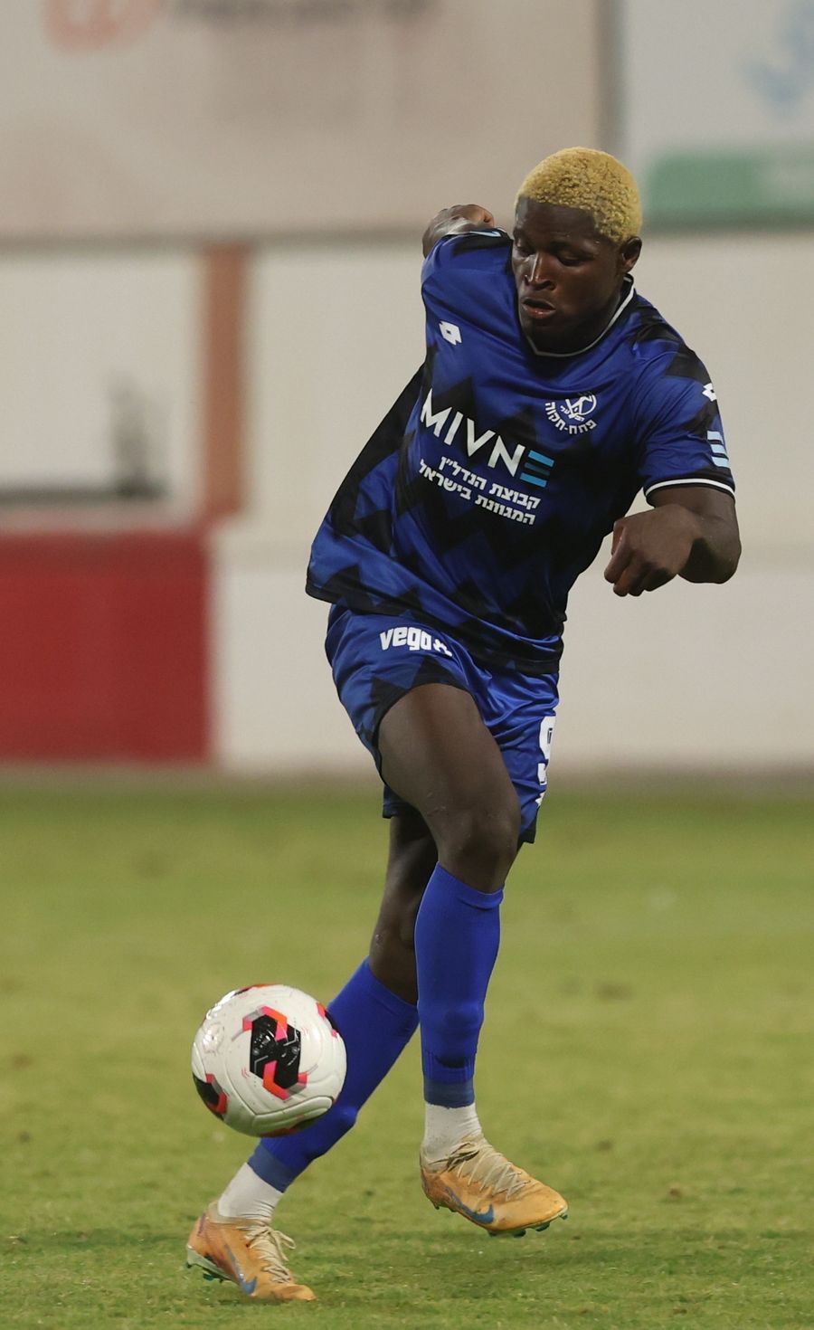 Yves Erick Bile (Hapoel Petah Tikva) strikes the ball with his right foot