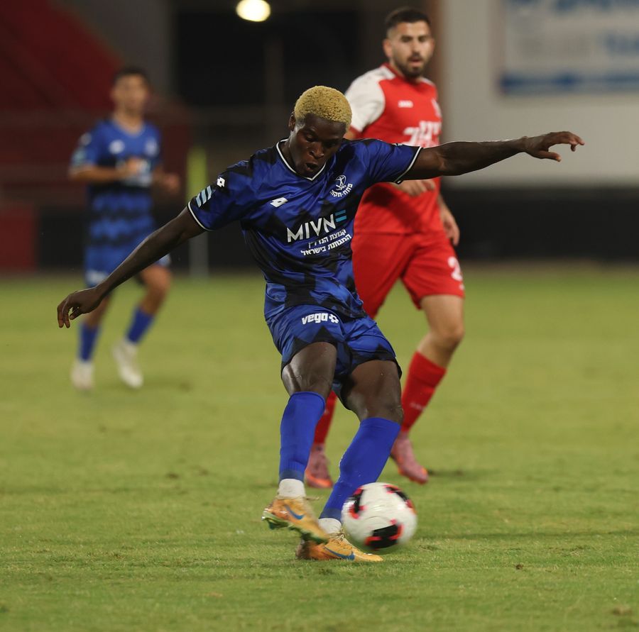 Yves Erick Bile (Hapoel Petah Tikva) strikes the ball from outside the box