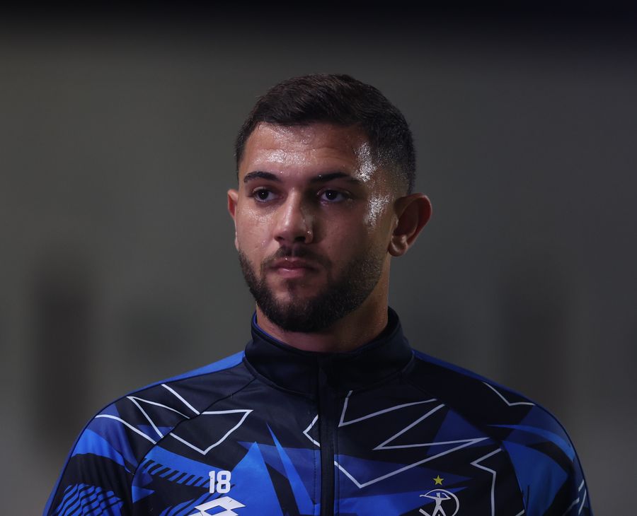 A footballer is standing and looking forward