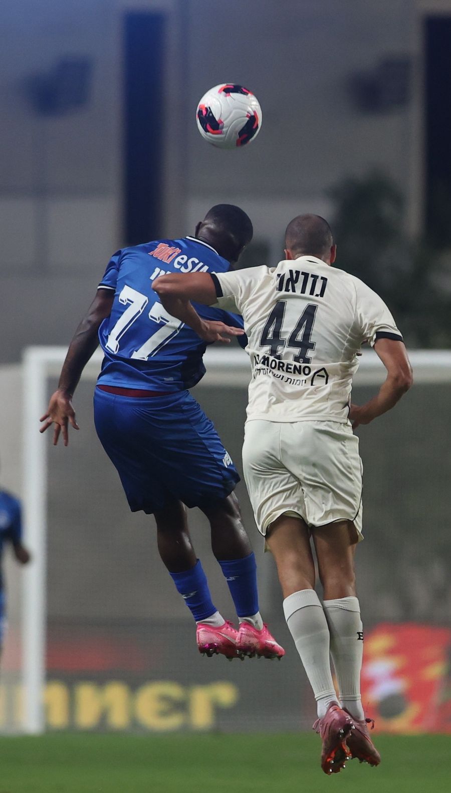 A footballer competes for an aerial ball