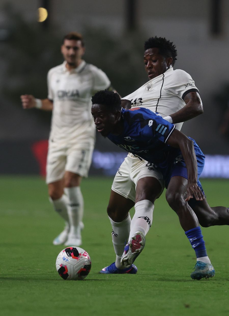 Karim Kimvuidi (Hapoel Petah Tikva) is being tackled by an opponent