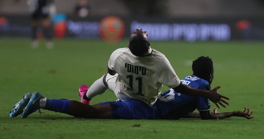 A footballer is being tackled by an opponent