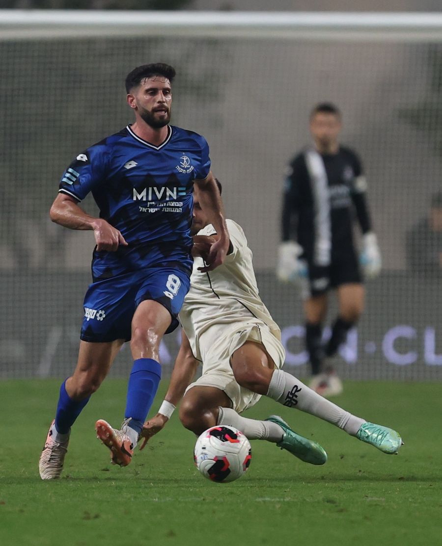 A footballer is attempting to control the ball