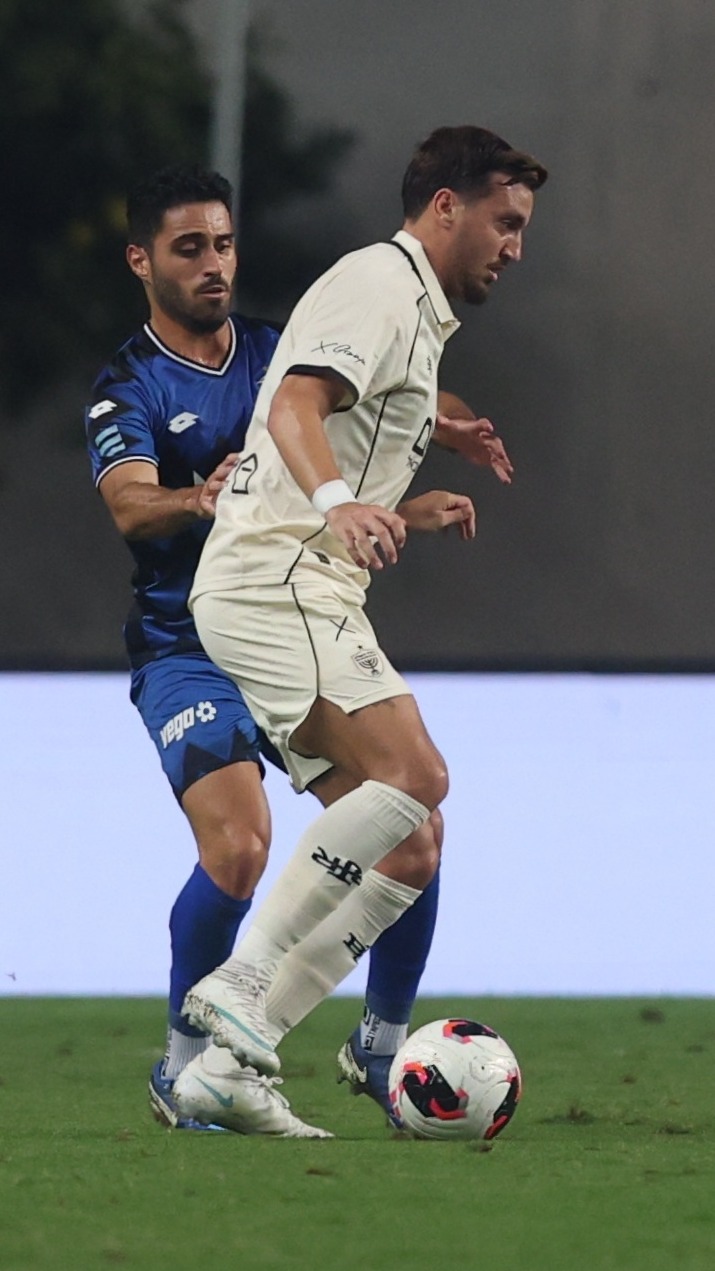 Stav Israeli (Hapoel Petah Tikva) is attempting to control the ball while being challenged
