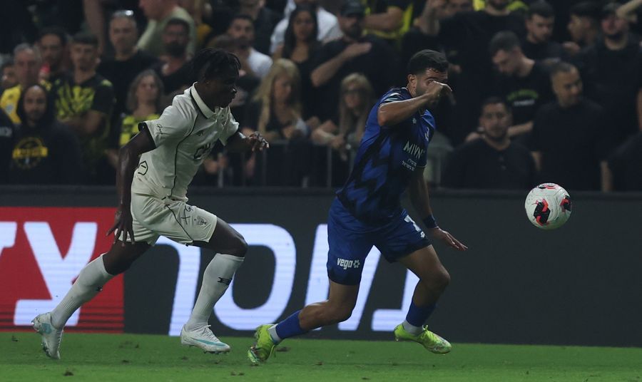 A footballer strikes the ball with his right foot