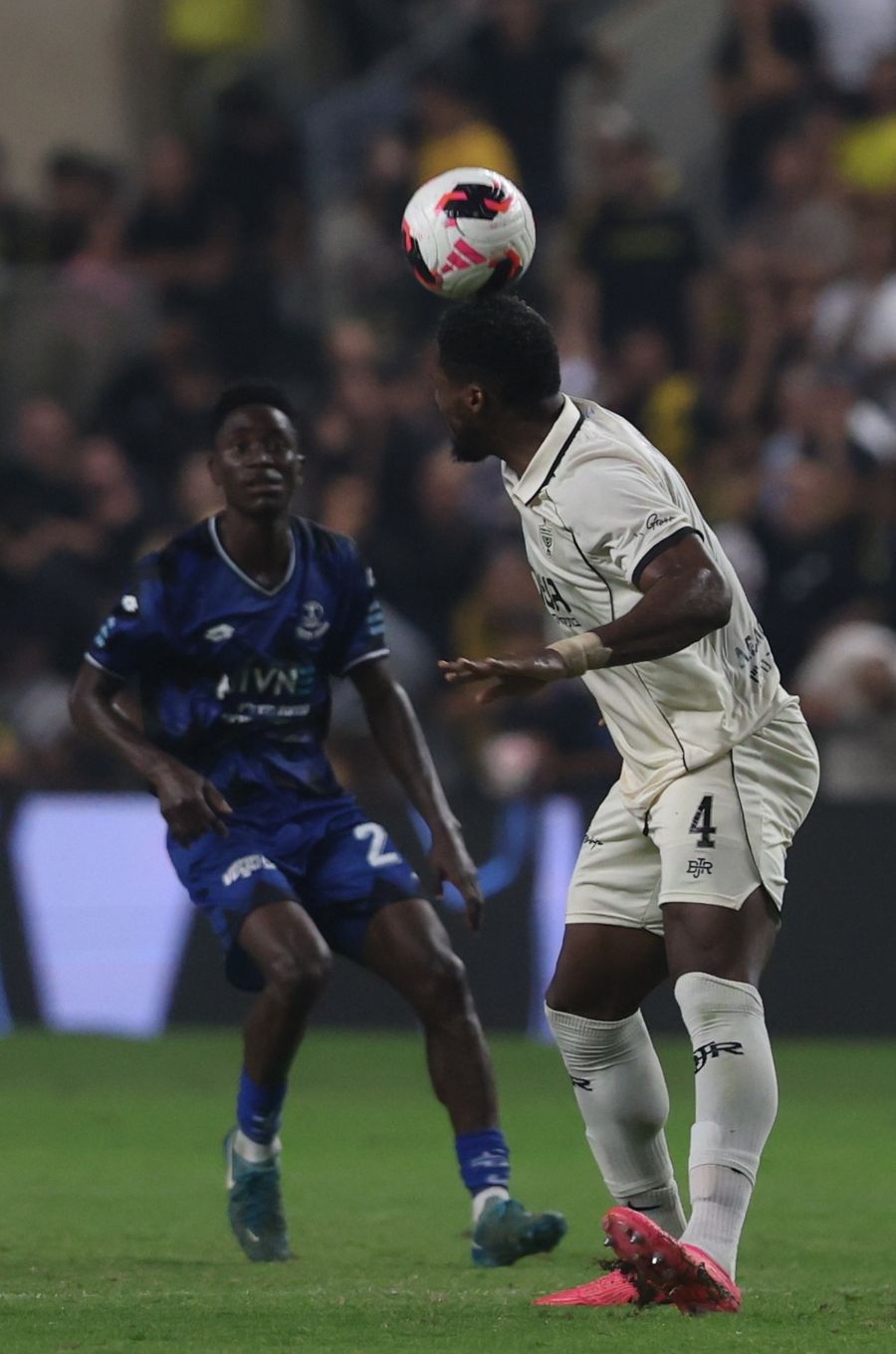 A footballer competes for an aerial ball