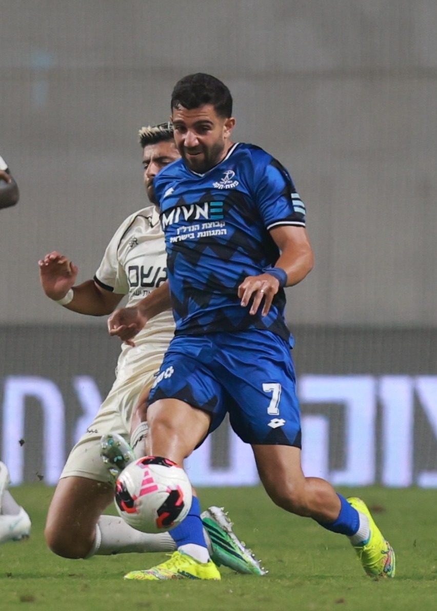 Roy Levy (#7, Hapoel Petah Tikva) strikes the ball from outside the box