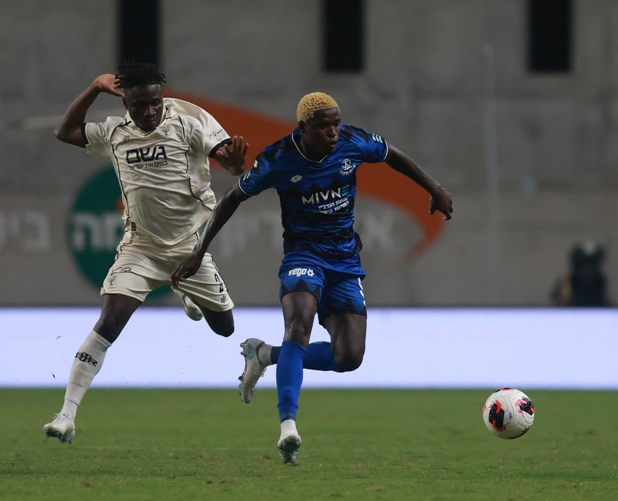 Yves Erick Bile (Hapoel Petah Tikva) runs towards the ball as Nana Antwi (Beitar Jerusalem) runs towards the ball