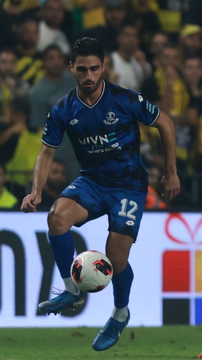 Stav Israeli (#12, Hapoel Petah Tikva) strikes the ball with his right foot