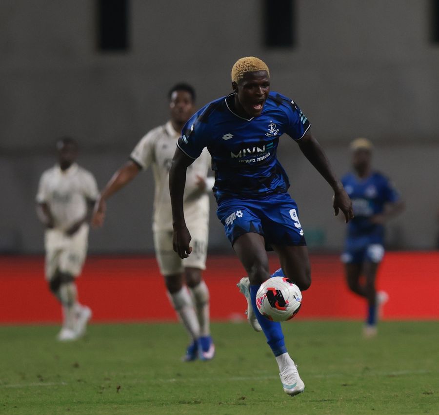 Yves Erick Bile (#9, Hapoel Petah Tikva) strikes the ball from outside the box