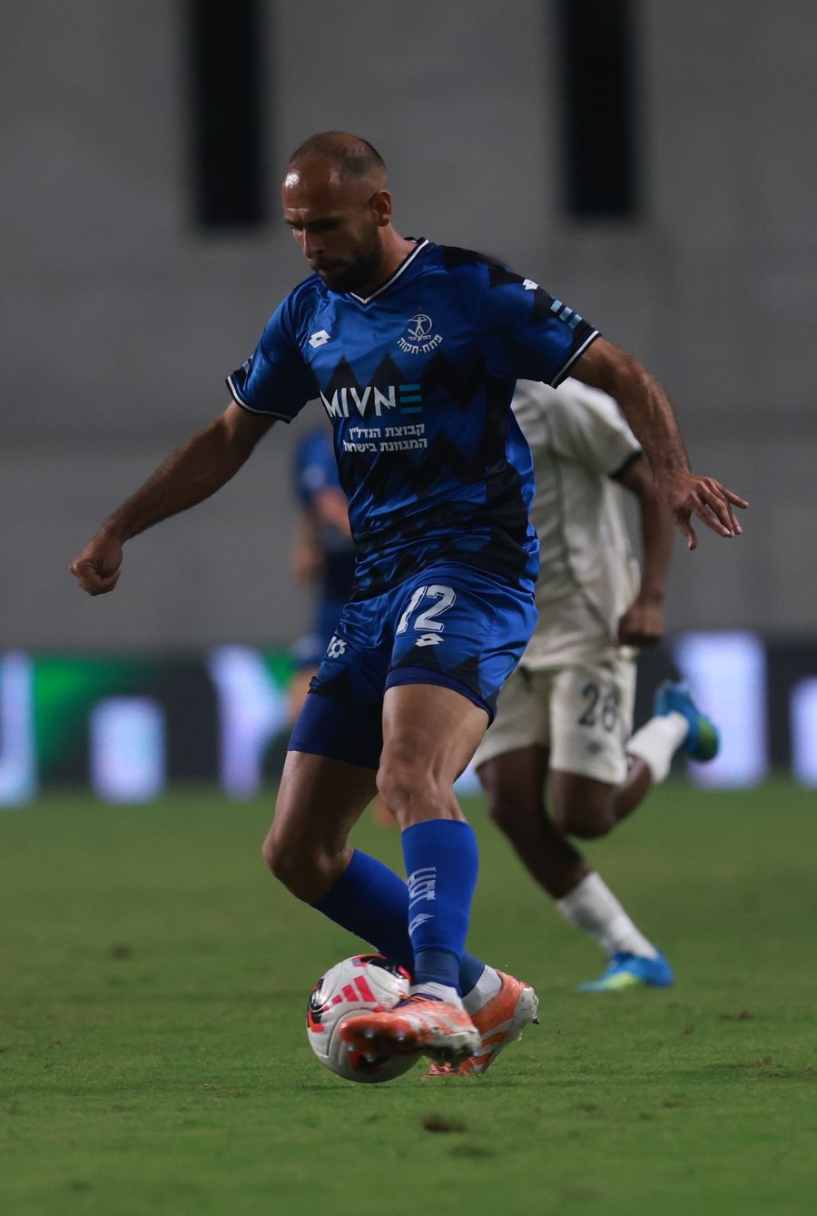 Stav Israeli (#12, Hapoel Petah Tikva) strikes the ball from outside the box