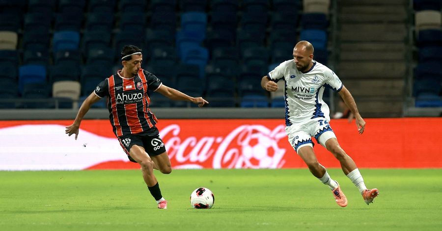 Yaad Gonen (Hapoel Haifa) dribbles the ball down the field as Yazen Nassar (Hapoel Petah Tikva) runs towards the ball