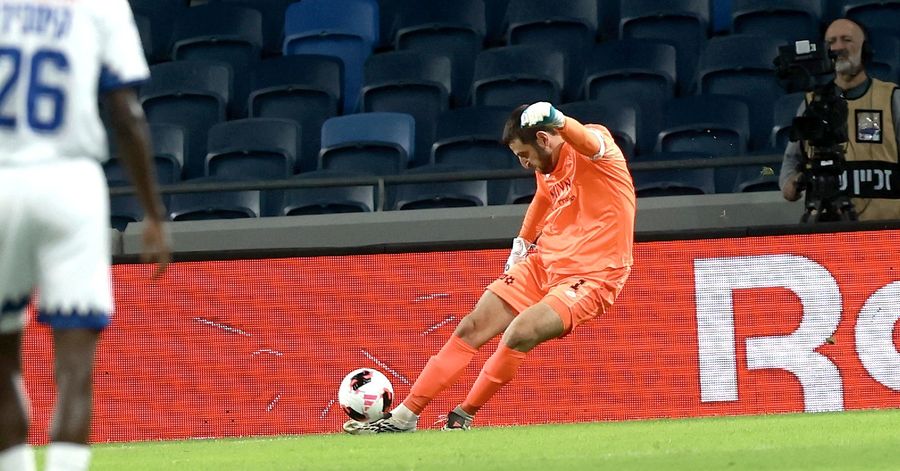 A footballer dives to block a shot