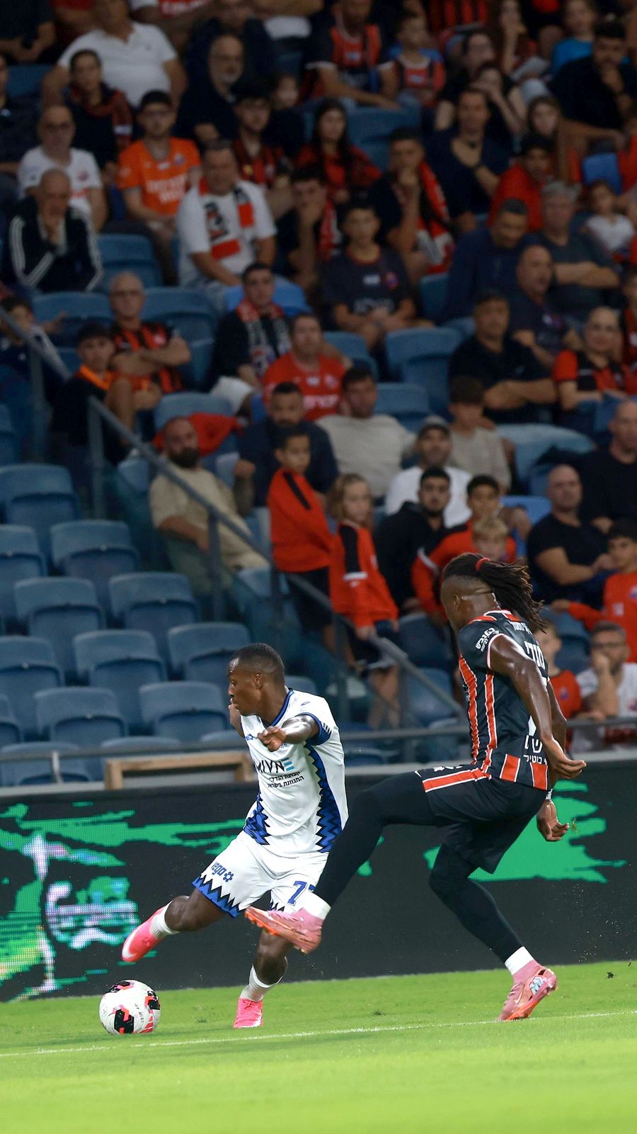 A Hapoel Petah Tikva player strikes the ball with his right foot
