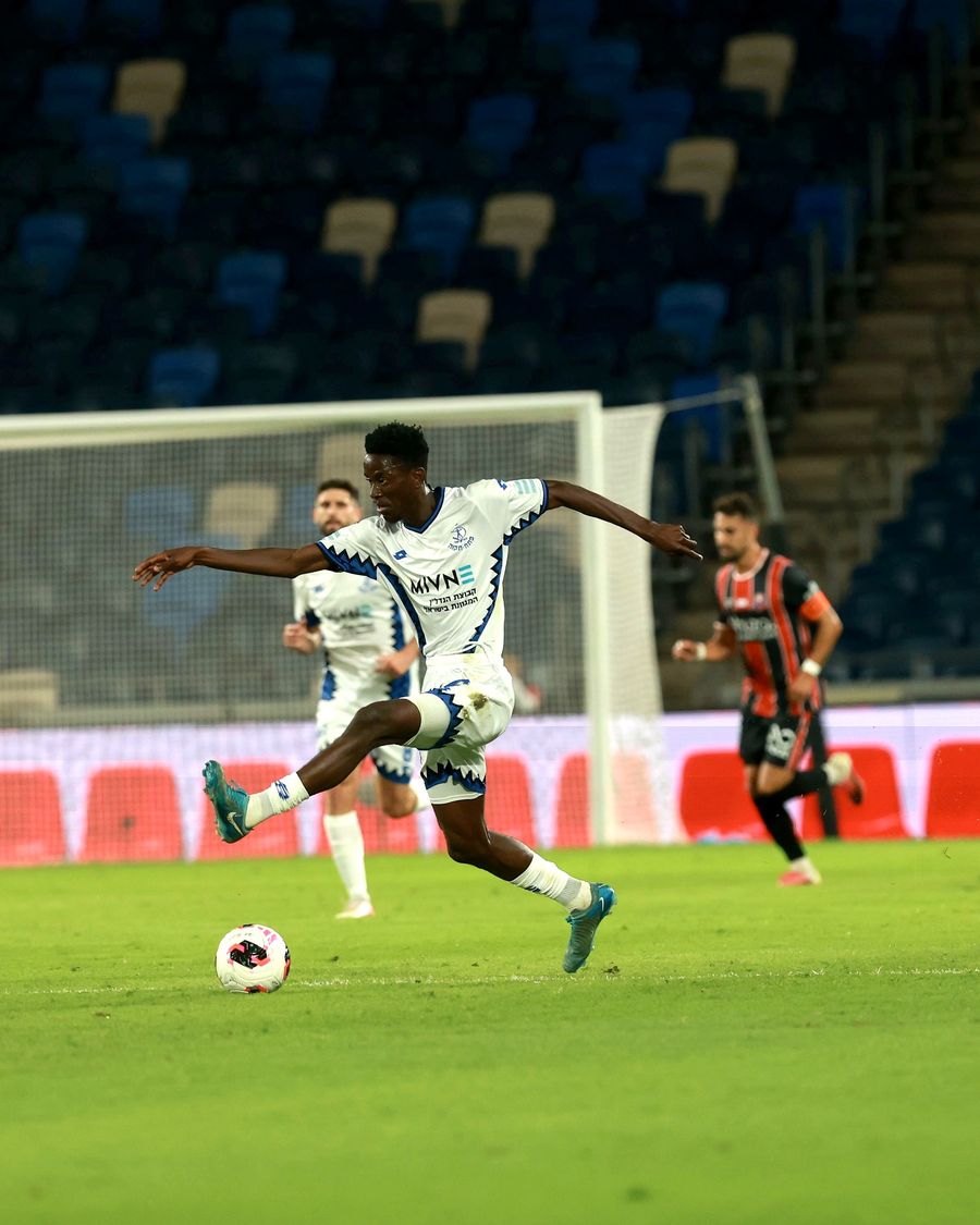 Karim Kimvuidi (Hapoel Petah Tikva) strikes the ball from outside the box