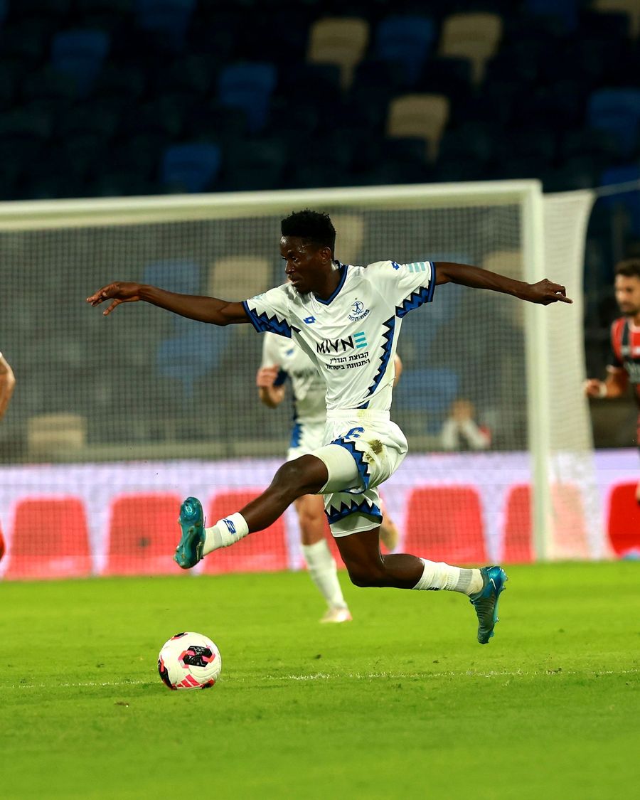 Karim Kimvuidi (Hapoel Petah Tikva) strikes the ball from outside the box