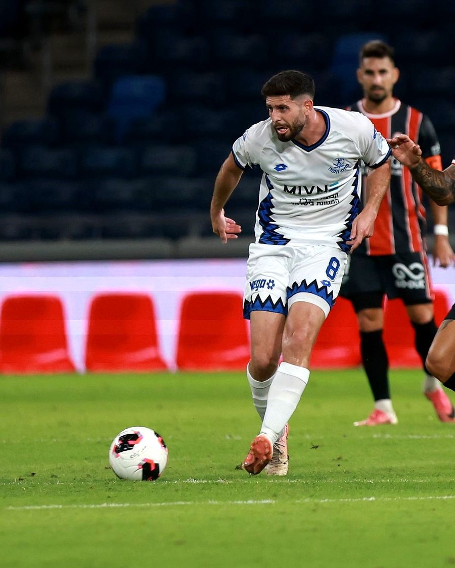 Tomer Altman (#8, Hapoel Petah Tikva) strikes the ball with his right foot as Alon Turgeman (Hapoel Haifa) defends