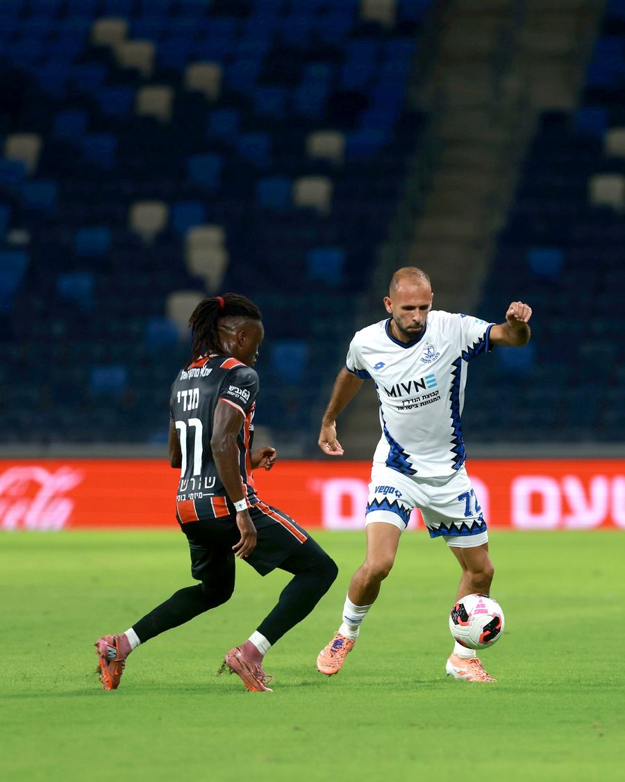 A Hapoel Petah Tikva player strikes the ball with his right foot