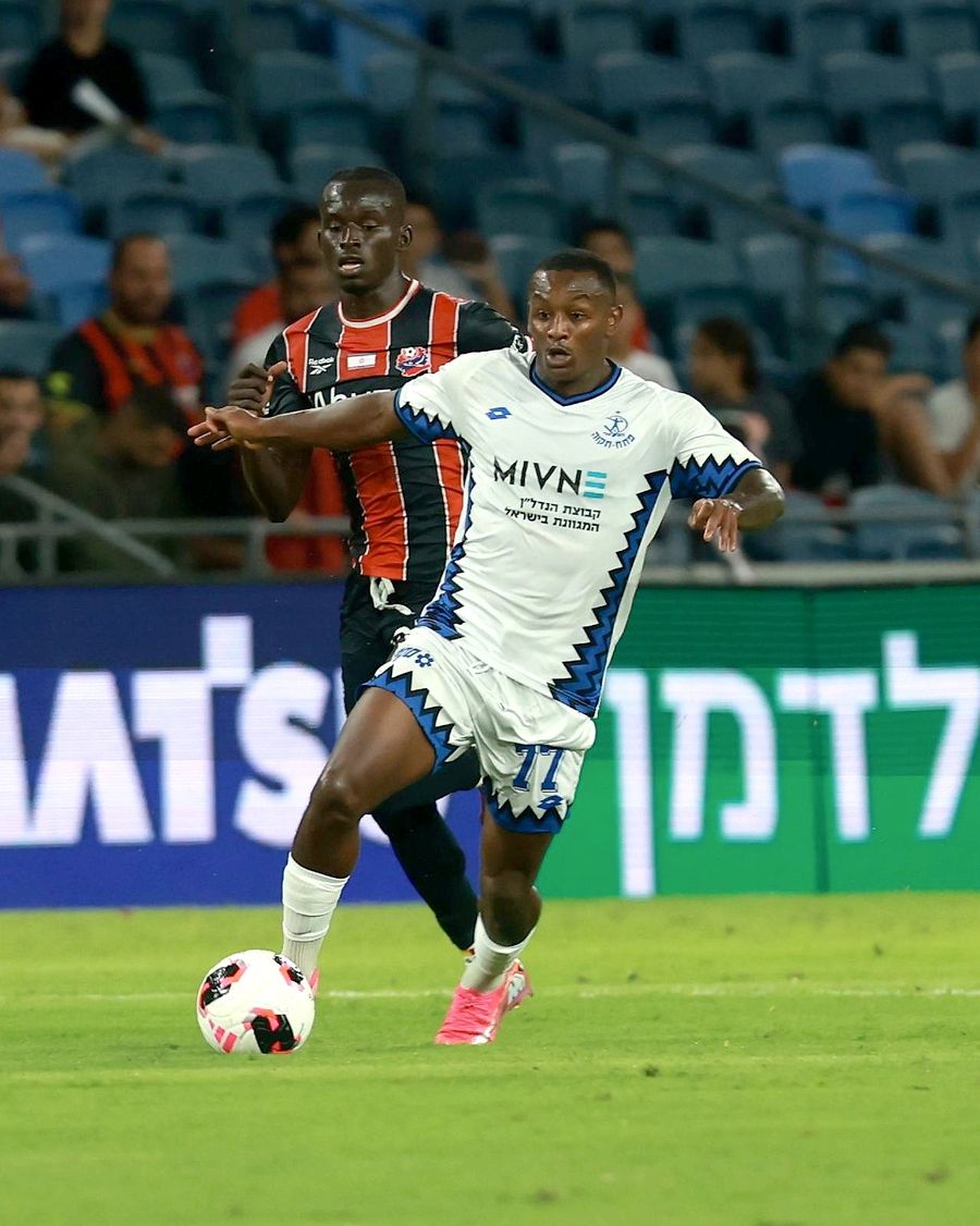 Clé (#77, Hapoel Petah Tikva) strikes the ball from outside the box