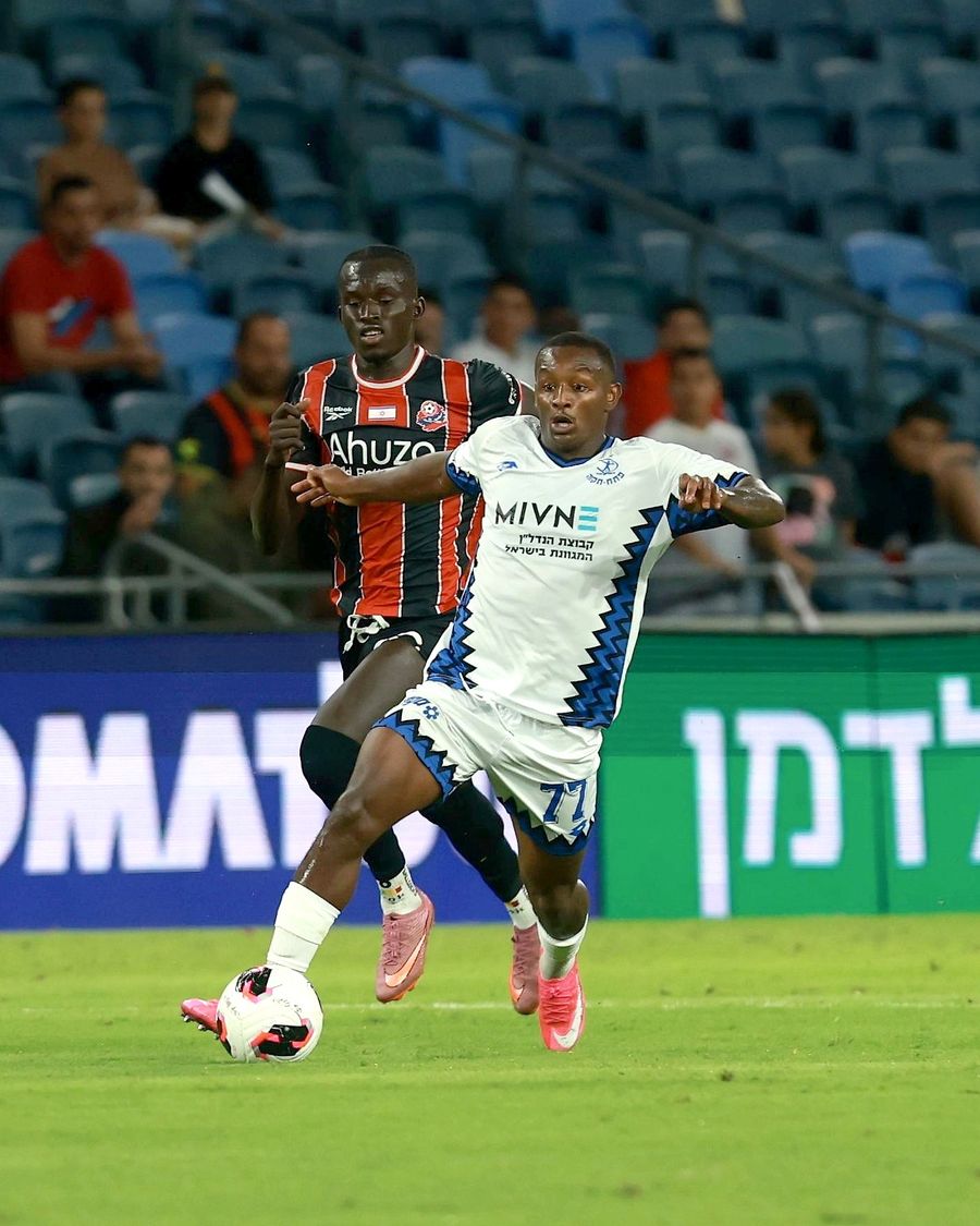 Clé (#77, Hapoel Petah Tikva) strikes the ball from outside the box