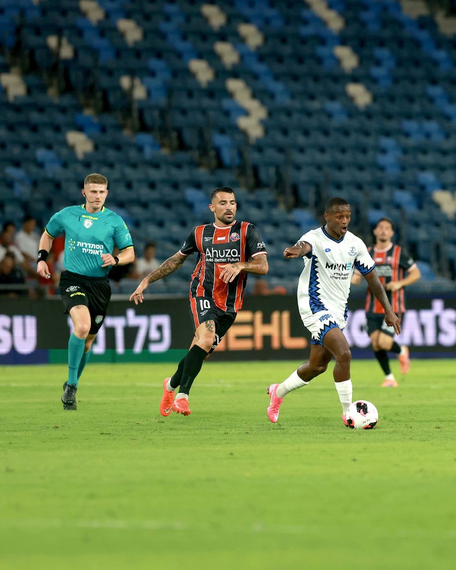 Clé (Hapoel Petah Tikva) controls the ball as Shay Elias (Hapoel Haifa) runs towards the ball
