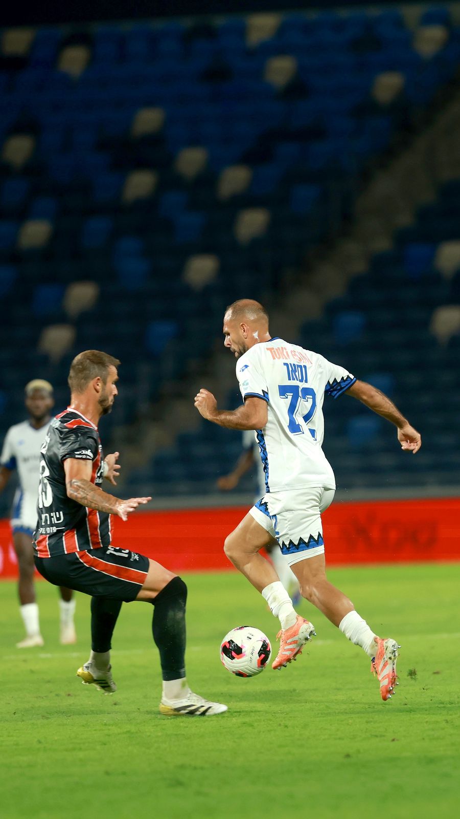 Yazen Nassar (Hapoel Petah Tikva) strikes the ball with his right foot as Dario Župarić (Hapoel Haifa) is attempting to block the ball