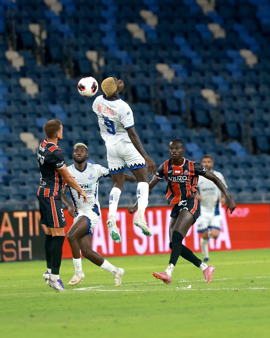 A Hapoel Petah Tikva player competes for an aerial ball during a match