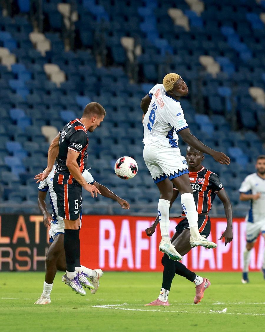 A Hapoel Petah Tikva player heads the ball while jumping