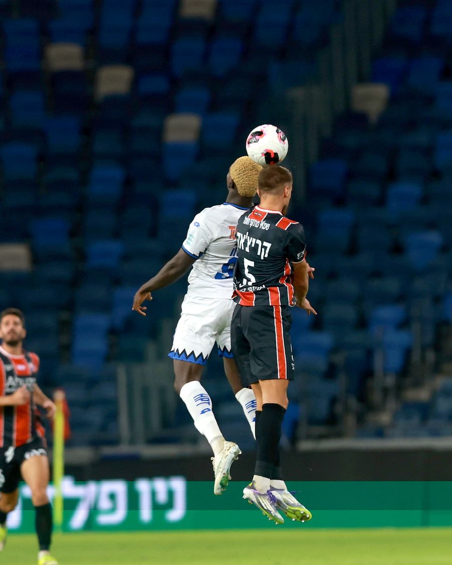 A Hapoel Petah Tikva player jumps to head the ball