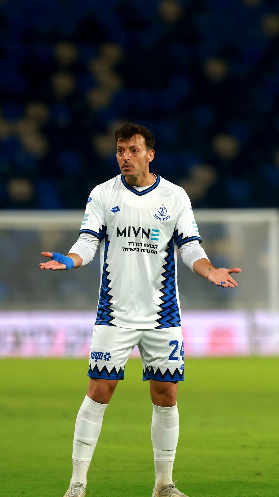 Guy Badash (#24, Hapoel Petah Tikva) is gesturing with both hands open during a match
