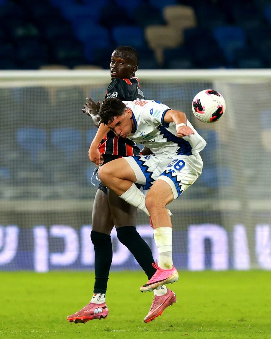 A Hapoel Petah Tikva player jumps to head the ball