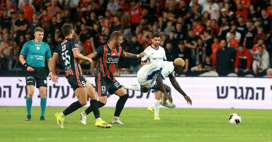Roy Levy (Hapoel Petah Tikva) defends the ball as Dario Župarić (#13, Hapoel Haifa) is attempting to block the ball